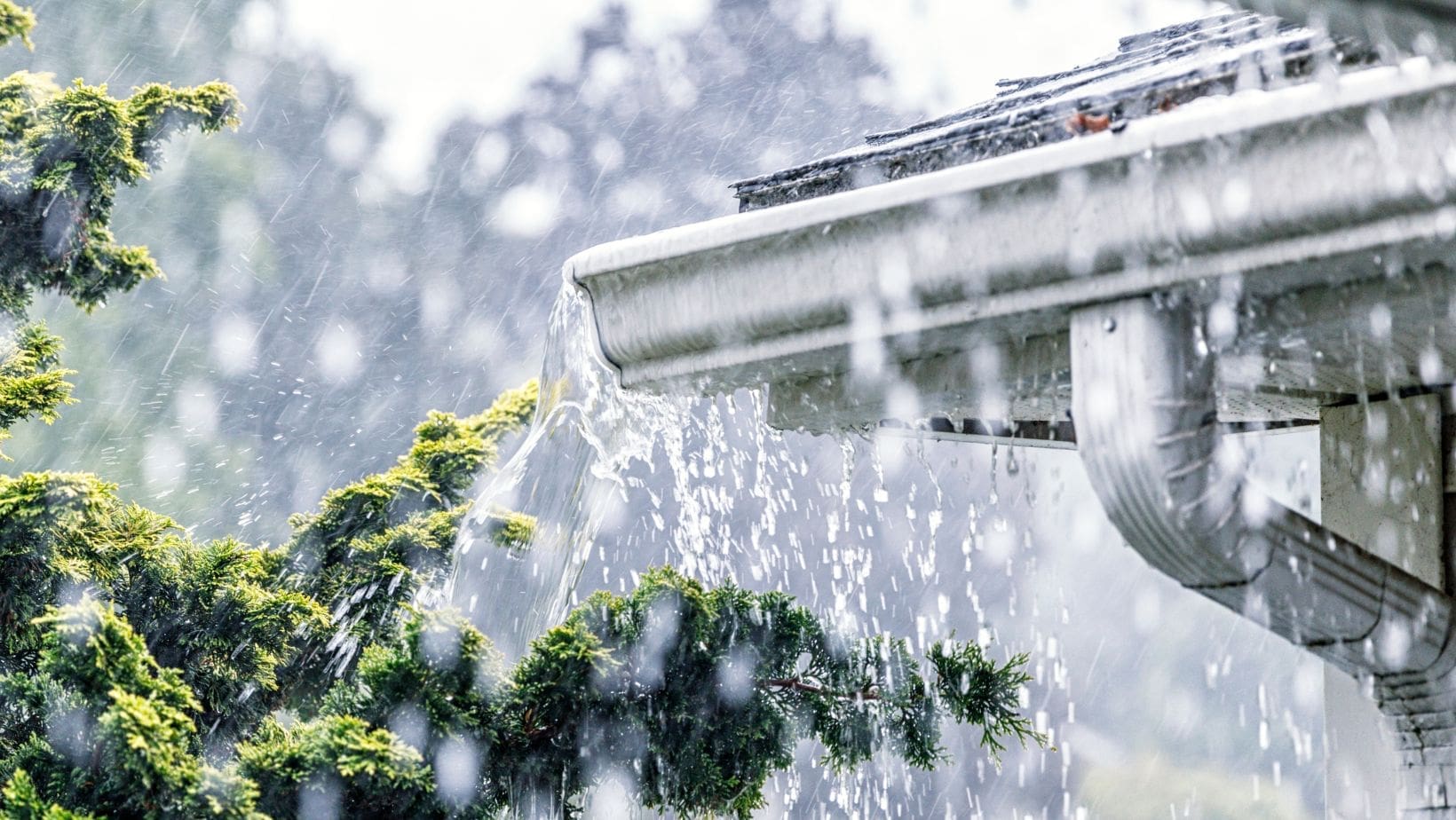 A residential gutter during a heavy storm, with rainwater flowing through, highlighting the importance of proper drainage. Empire Contractors LLC provides expert gutter installation, cleaning, and maintenance services in Cincinnati, OH, and surrounding areas to protect homes from water damage.