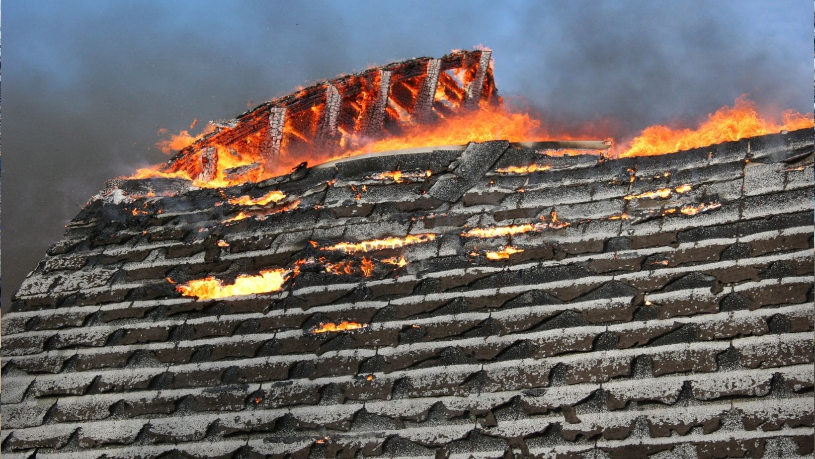 A residential roof with visible fire damage, including charred shingles and structural deterioration. Empire Contractors LLC provides professional fire-damaged roof repair and replacement services in Cincinnati, OH, and surrounding areas.